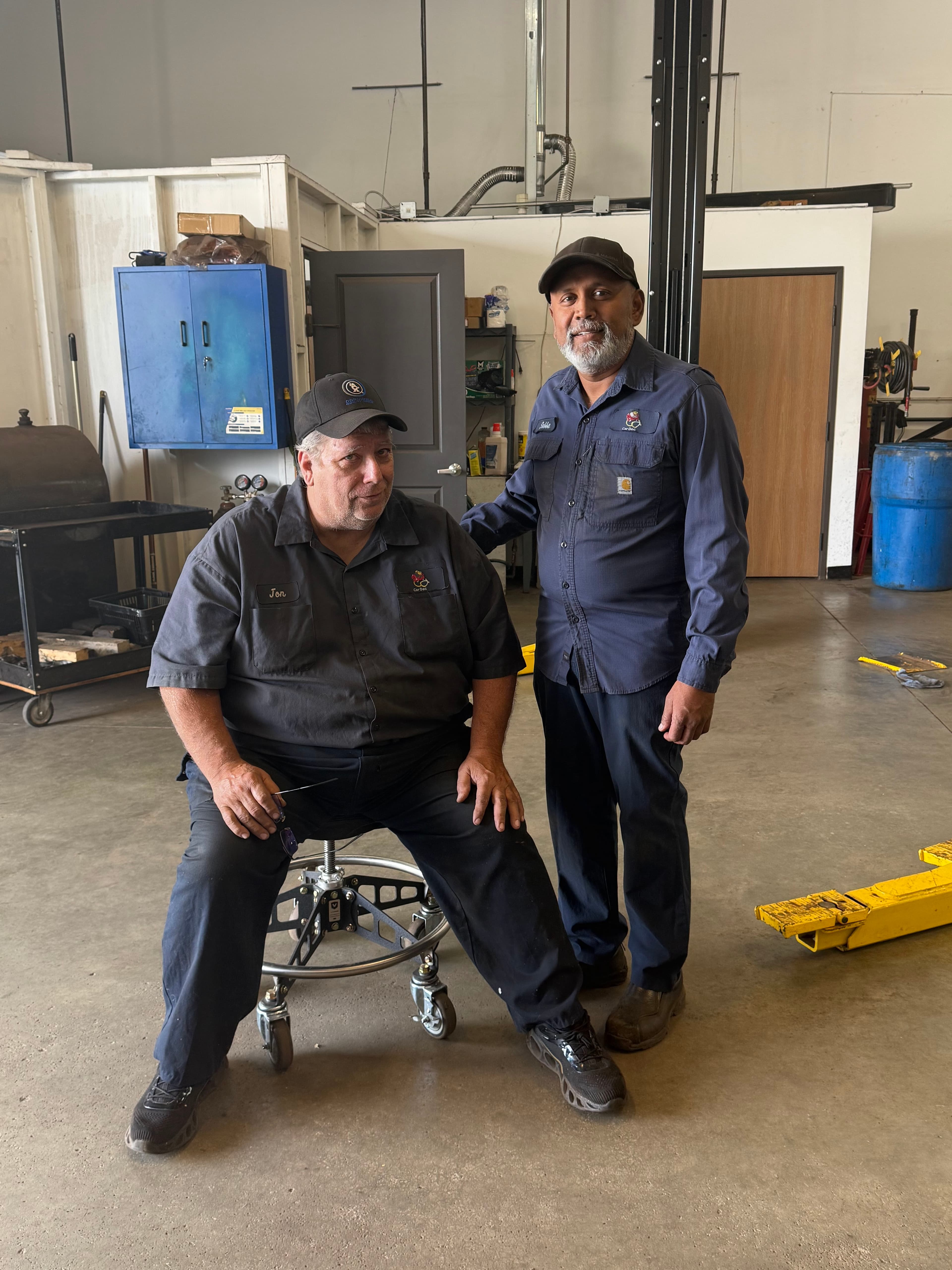 Subbu and Jon together in the Car Doc service shop